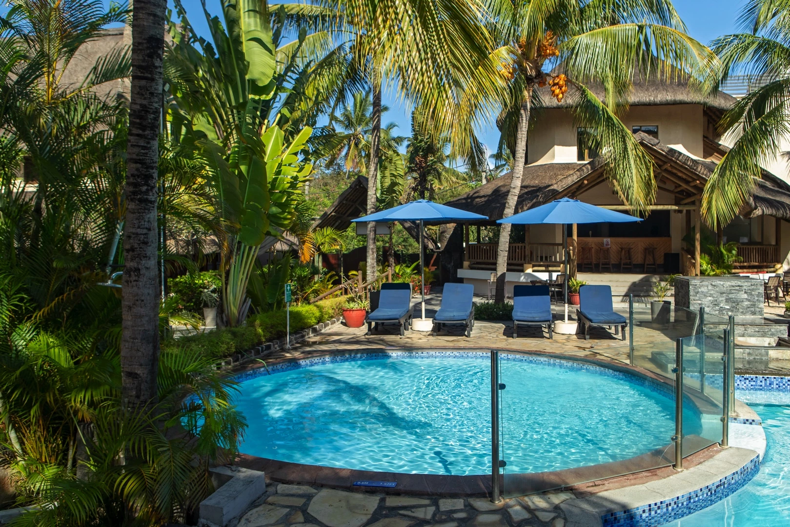 Relaxation pool at Le Palmiste Resort & Spa with sunbeds and palm trees