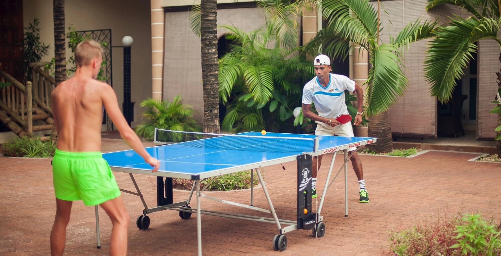 Guests playing table tennis at Le Palmiste Resort & Spa outdoor activity area